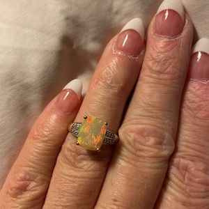 Solid 10carat yellow gold ring with opal center stone & genuine diamond accents.